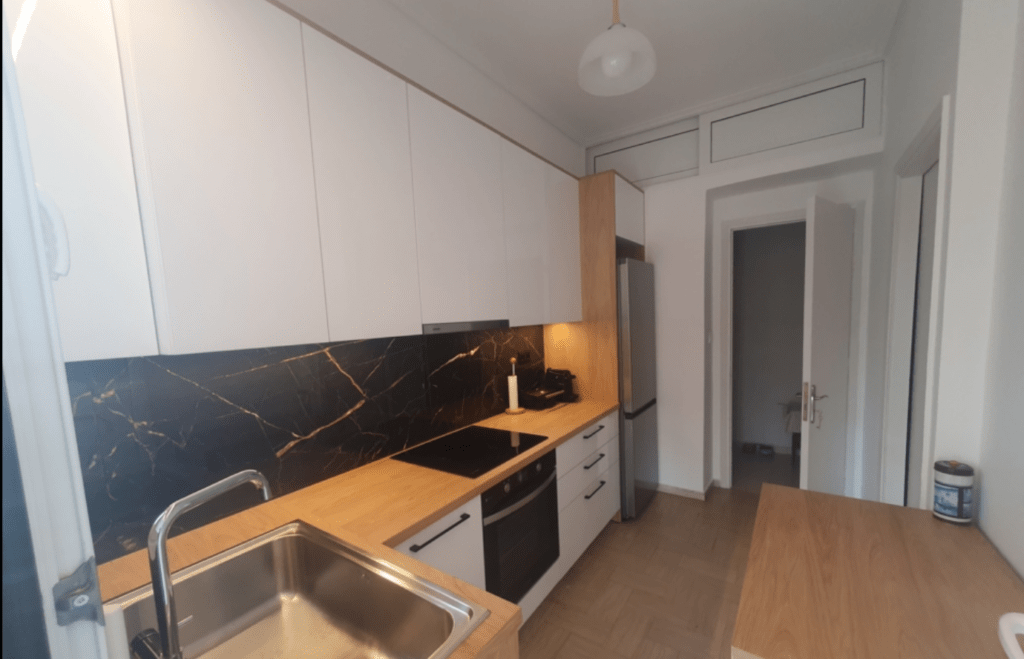 Κουζίνα μετά τη minimal ανακαίνιση με νέο πάγκο και φωτισμό στην Καλλιθέα